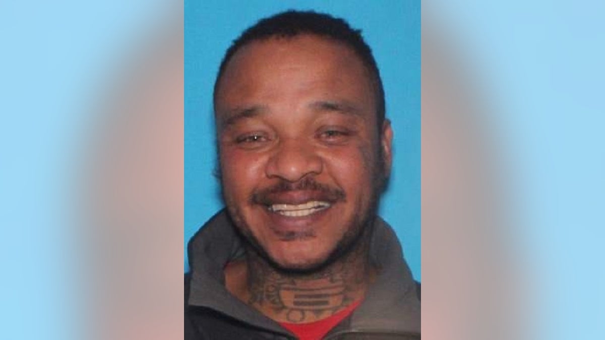 Justin Robinson smiling in booking photo