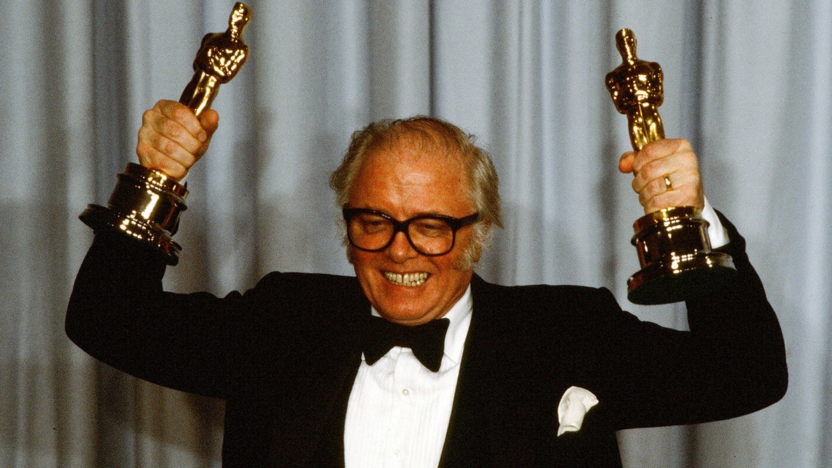 Richard Attenborough at the 1983 Academy Awards posing with the two Oscars he won