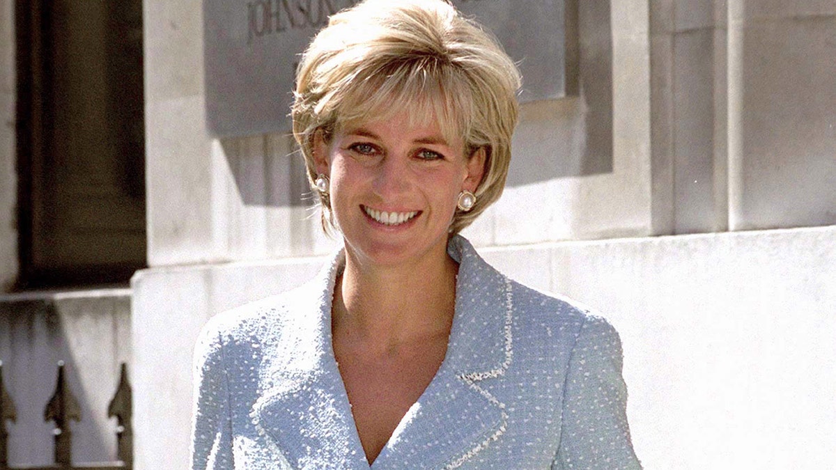 Princess Diana smiling while wearing a powder blue suit