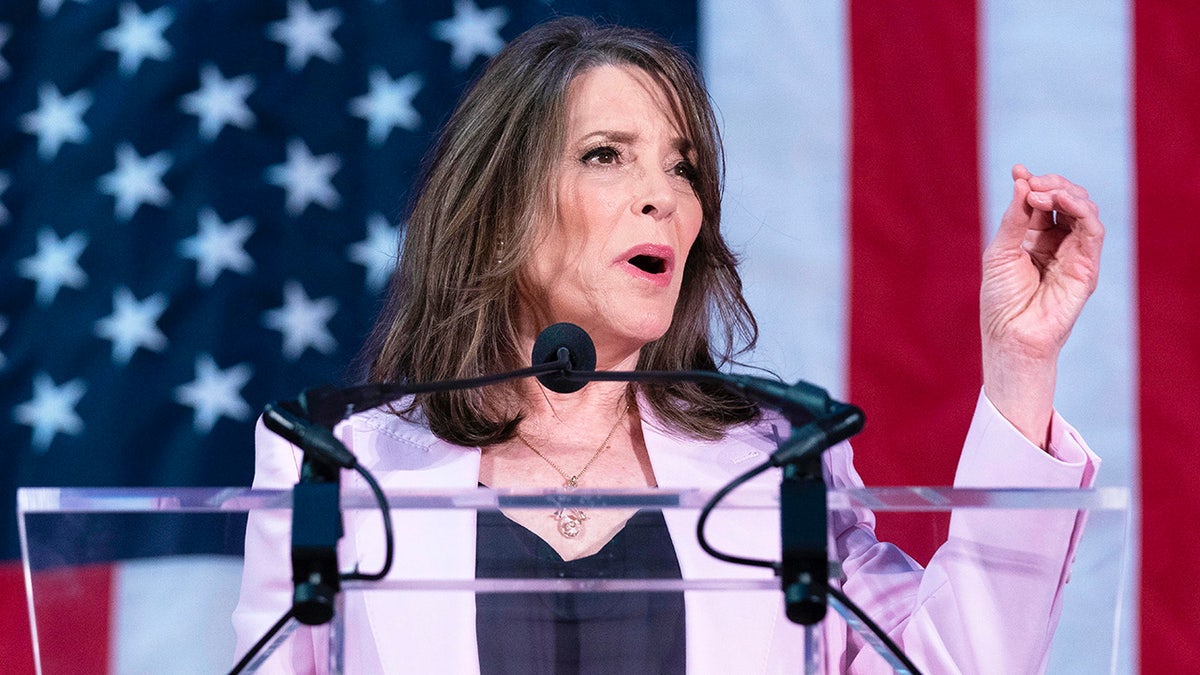 Marianne Williamson left hand raised at podium