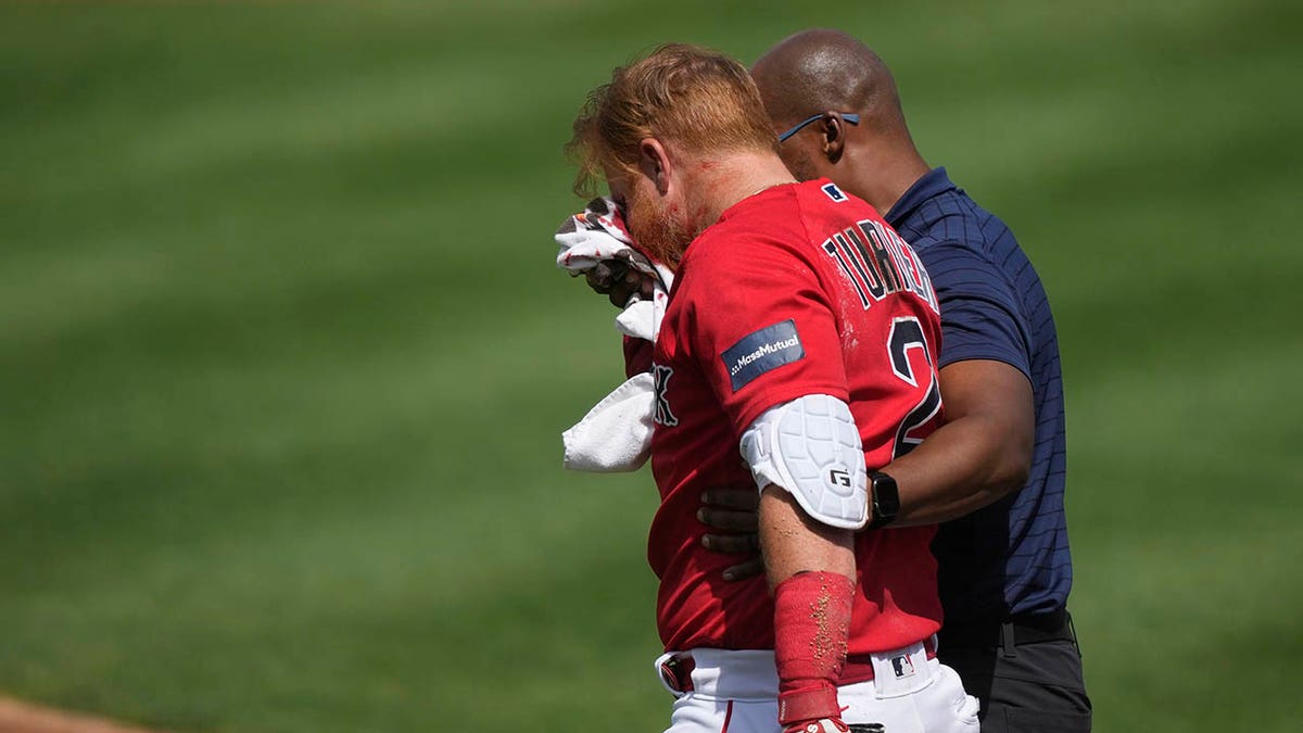 Boston Red Sox Justin Turner walks off the field after getting hit with a pitch