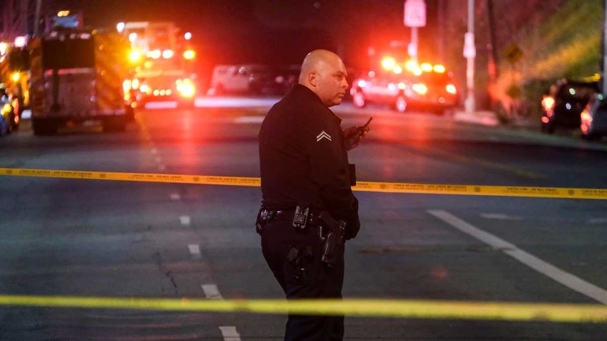 A police officer behind caution tape