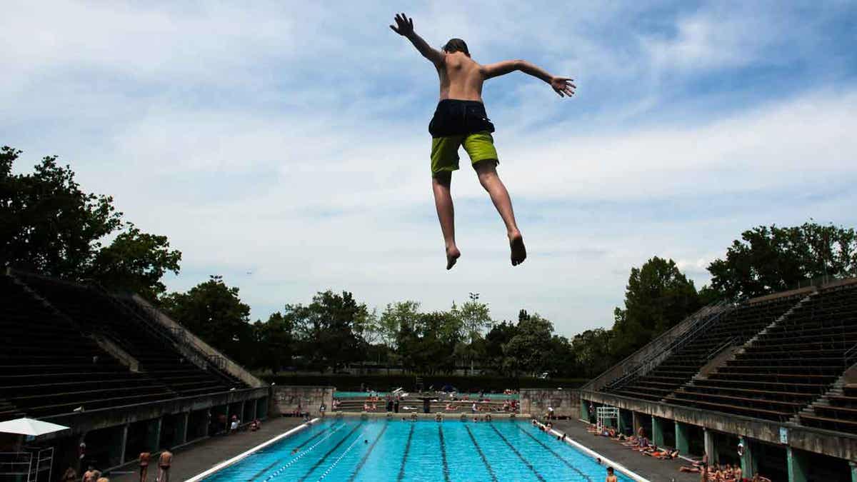 Boy jumping in a pool