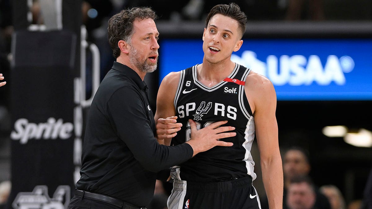Zach Collins is held back by a Spurs coach