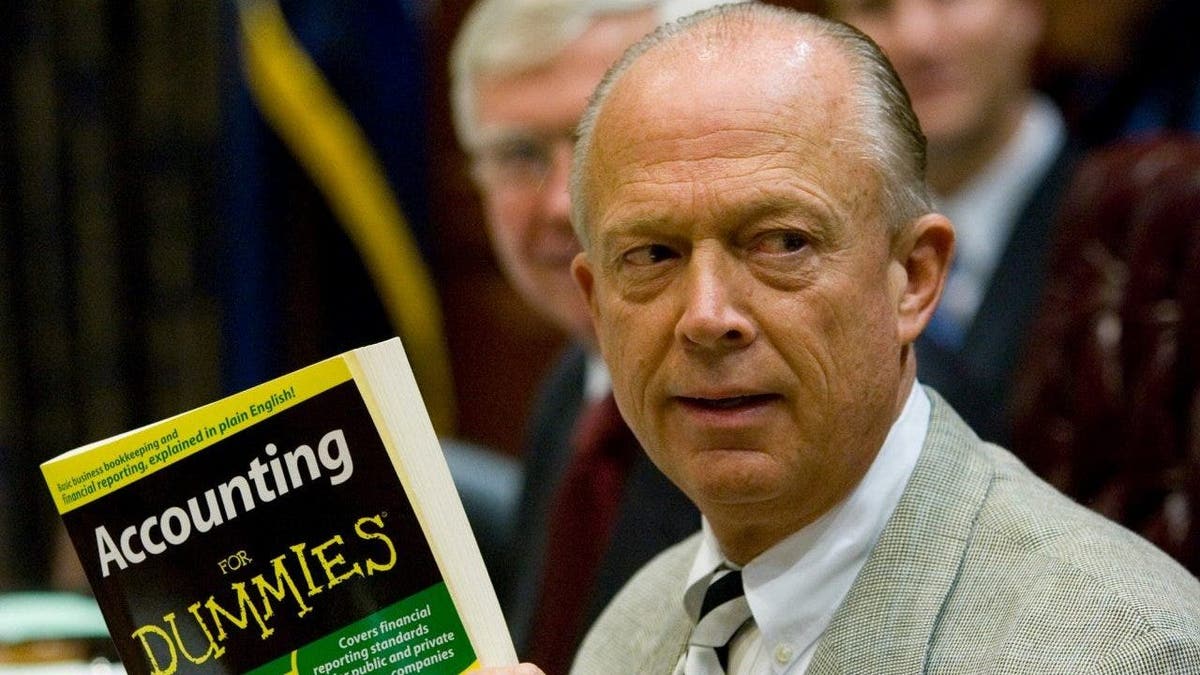 South Carolina Comptroller General Richard Eckstrom holds up a book he wanted to present to his new Chief of Staff James Holly during his introduction at the Budget and Control Board meeting, Aug. 13, 2009, in Columbia, S.C.