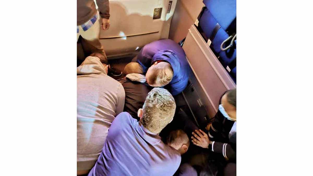 Passengers restraining someone on flight