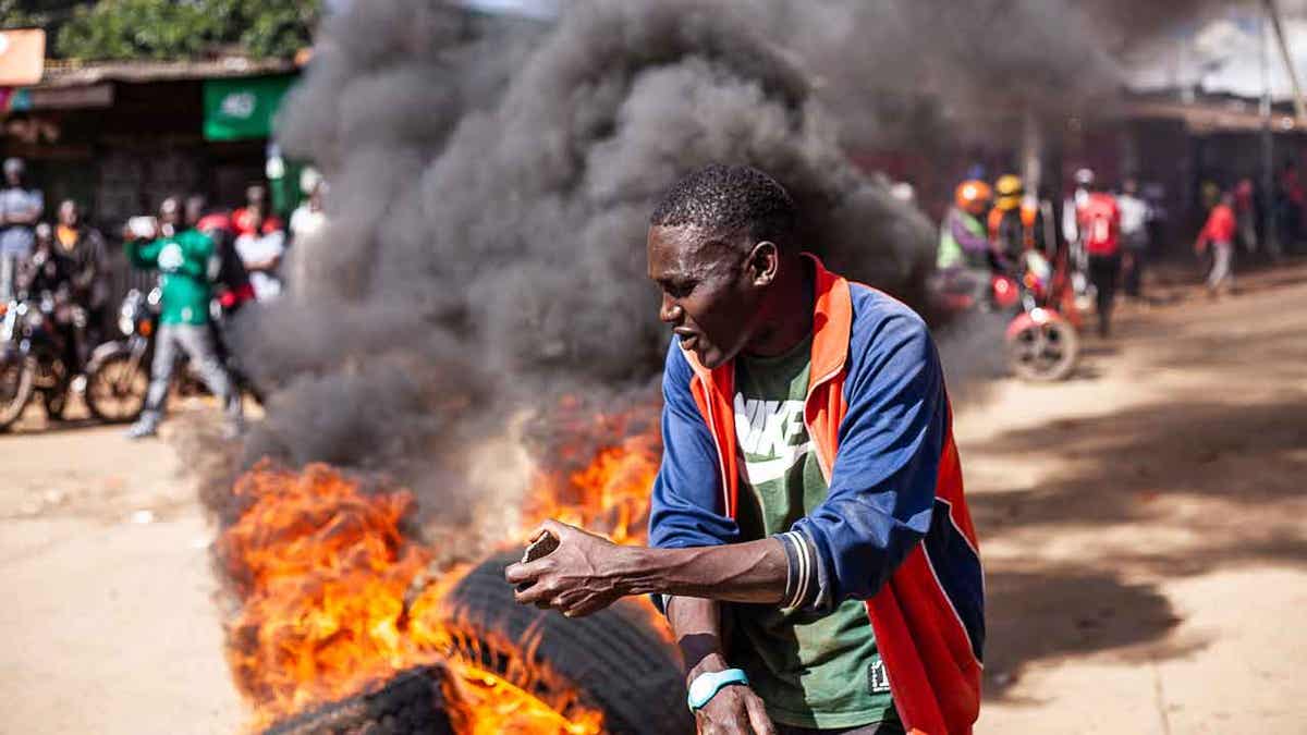 A protesters reacts next to a burning barricade 