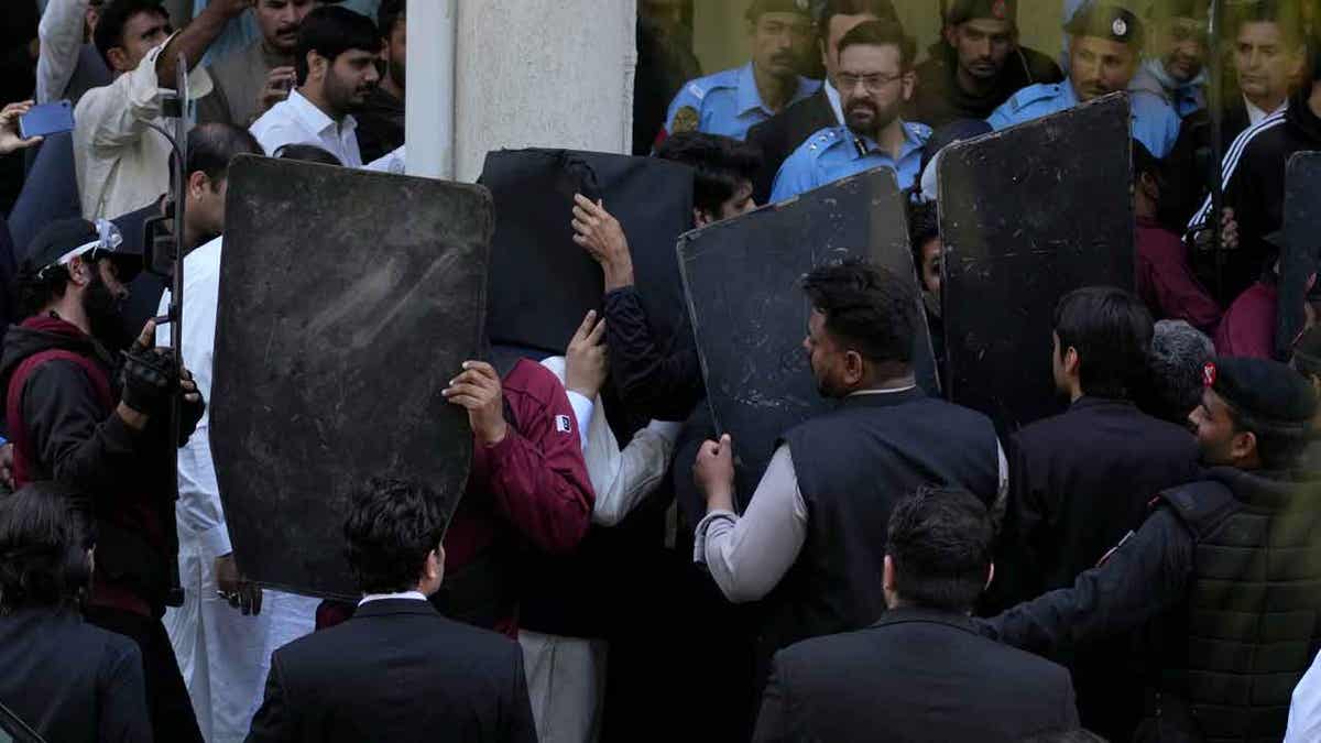 Security personnel with bulletproof shields for Imran Kahn