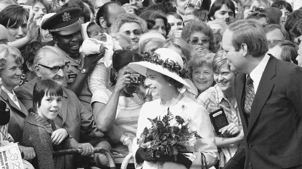 People gather to greet Britain's Queen Elizabeth II