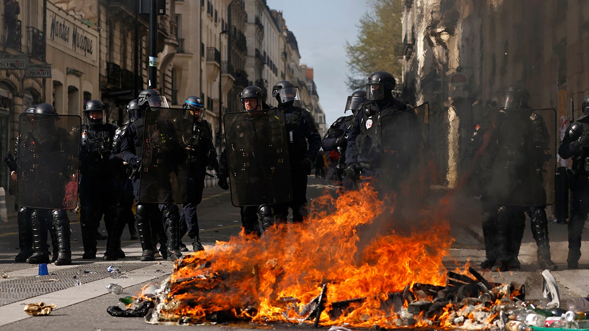 France police officers by fire from protests