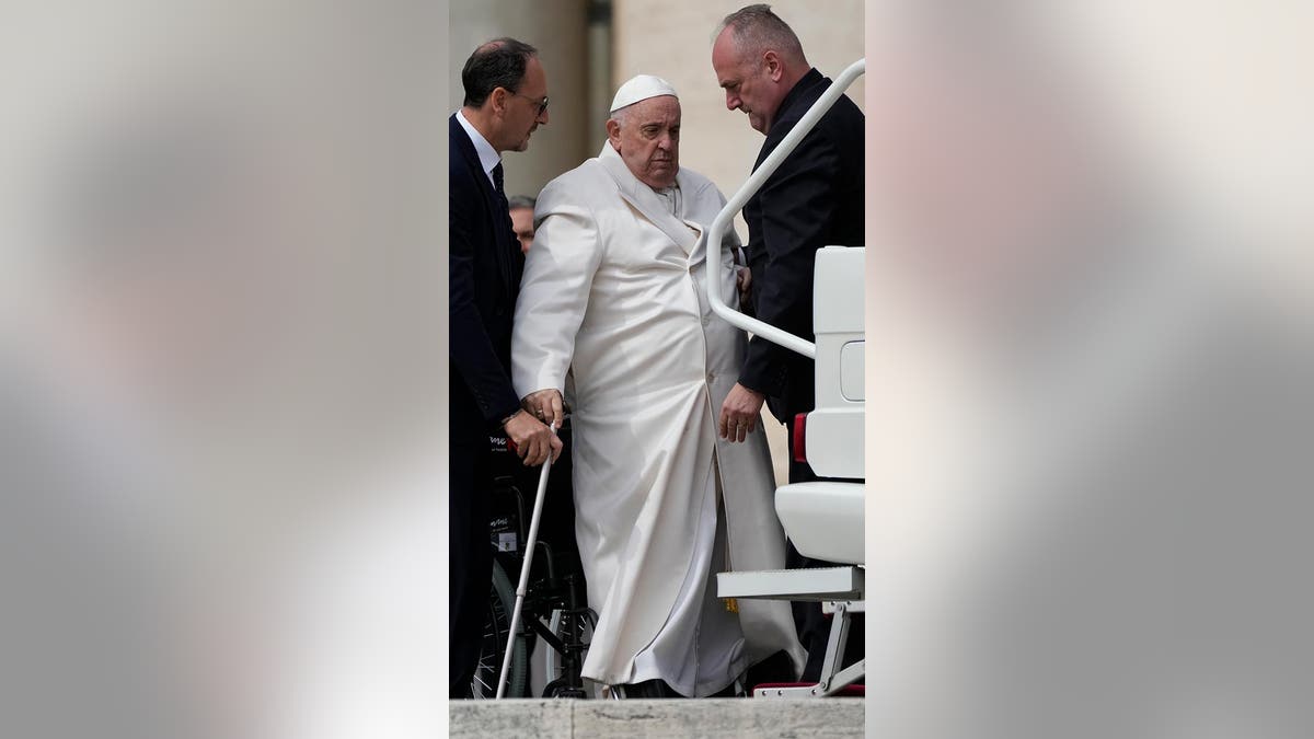 Pope Francis helped to get on his car at the end of weekly general audience in St. Peter's Square, at the Vatican, Wednesday, March 29, 2023. 