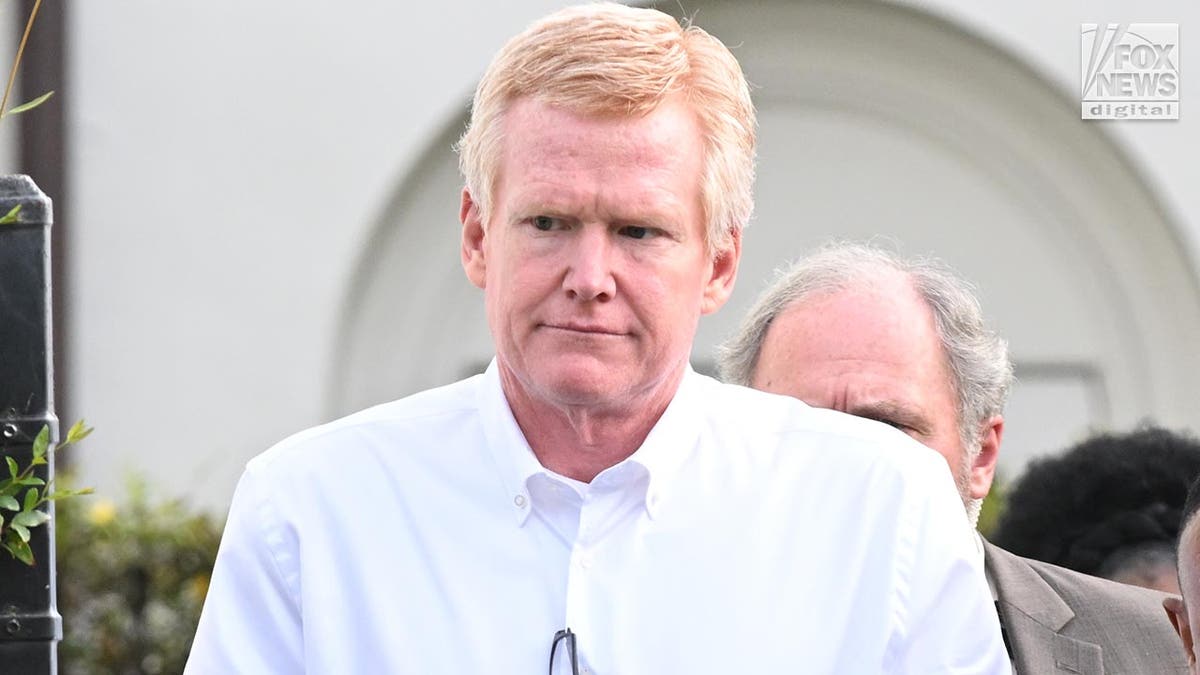 Murdaugh in a white button-down shirt looks to the side