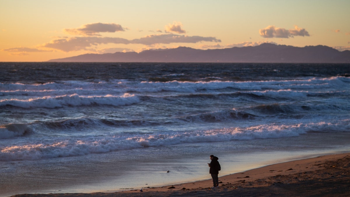 A person on the shores of Manhattan Beach, Calif.