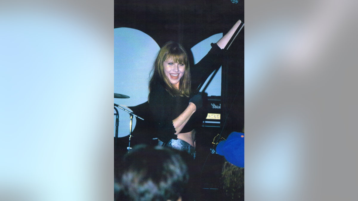 Bebe Buell smiling while on stage performing