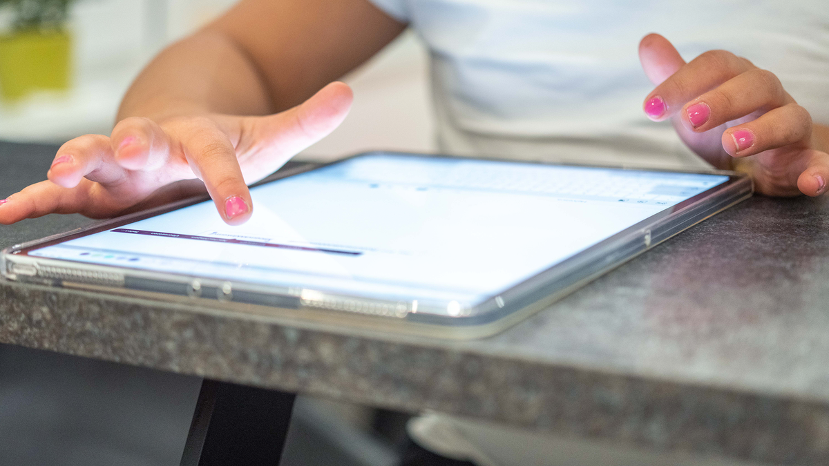 Child typing on iPad