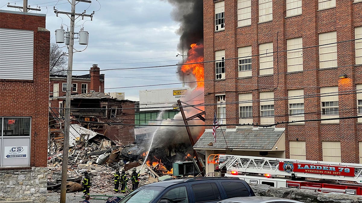 Firefighters dousing flames at an explosion