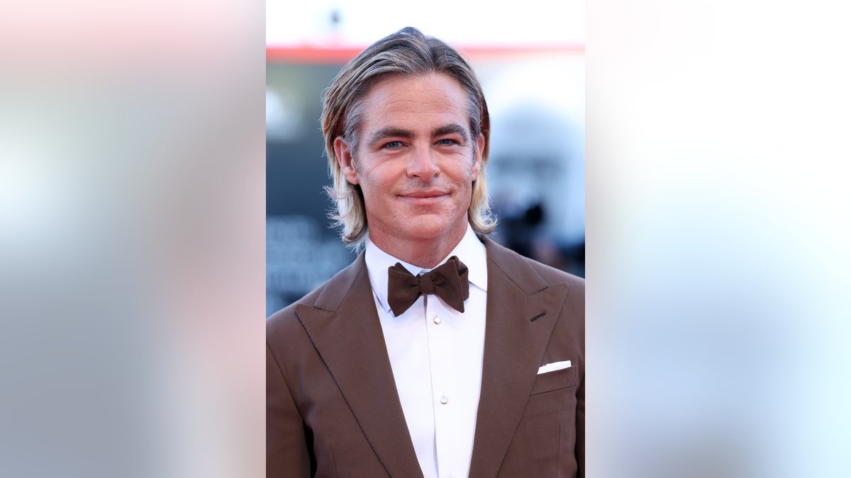 Chris Pine wears brown tuxedo and bow tie at Venice Film Festival