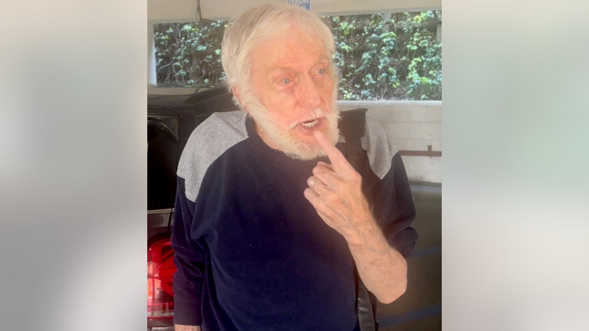 Dick Van Dyke points out the stiches on his lip in a parking garage
