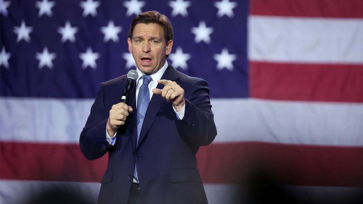 Ron DeSantis speaking in Iowa, US flag in background