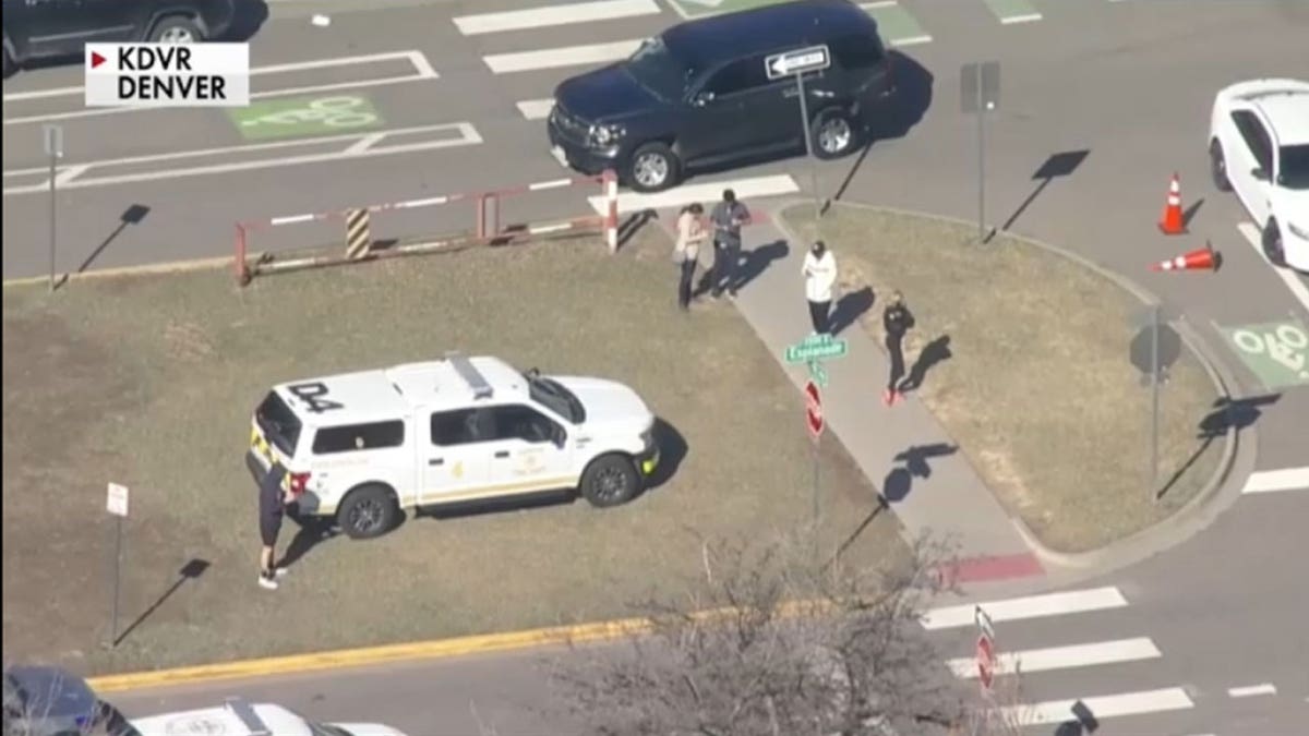 People standing at the median in front of East High School.