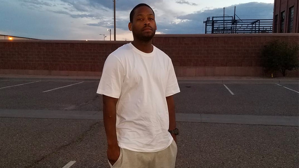 Don Juan Butler with hands in pockets, wearing T-shirt in parking lot