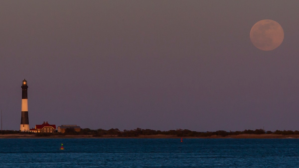 A supermoon over the Great South Bay and the Fire Island Lighthouse.