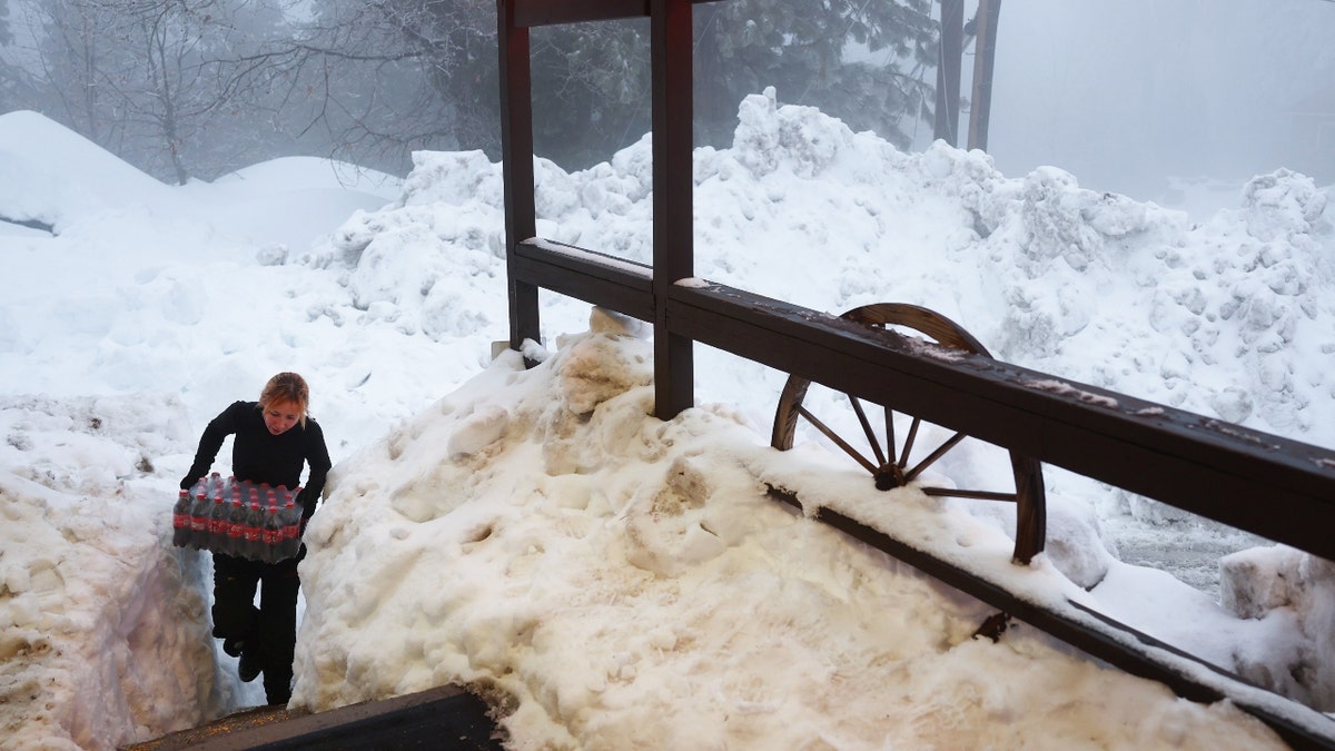 A woman carries food throw San Bernardino Mountain snow