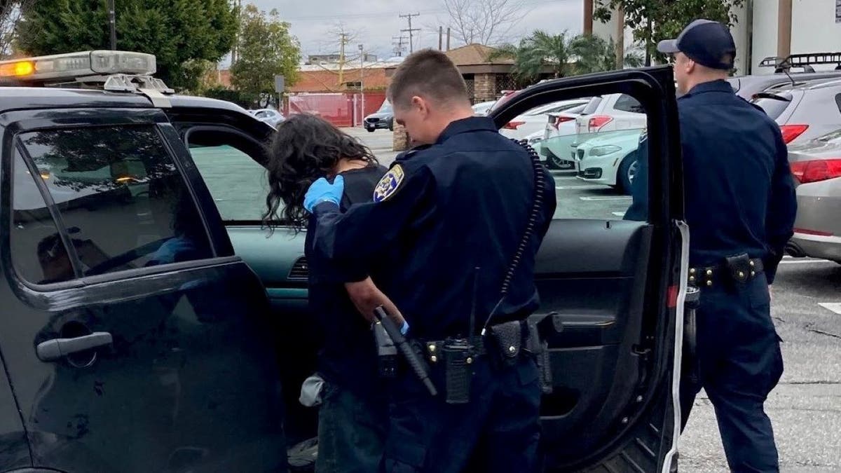 Suspect being guided to police car