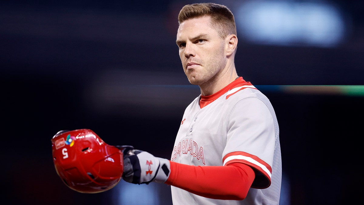 Freddie Freeman hands off helmet