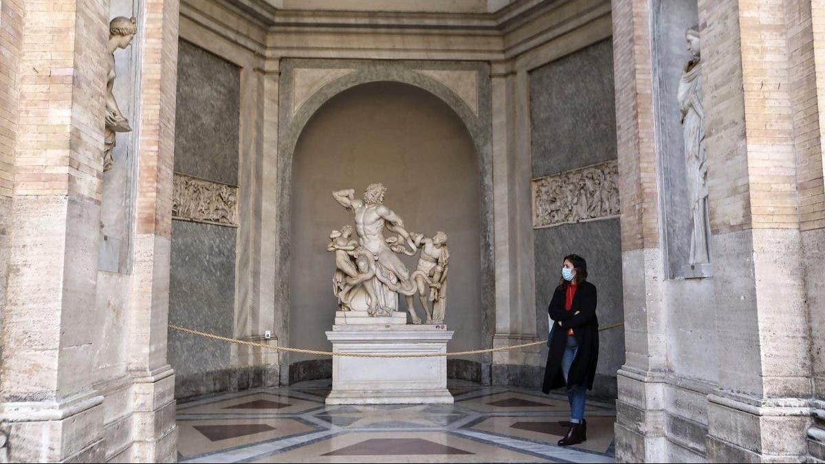 A visitor looks at the "Laocoön and His Sons" sculpture at the Vatican Museums.