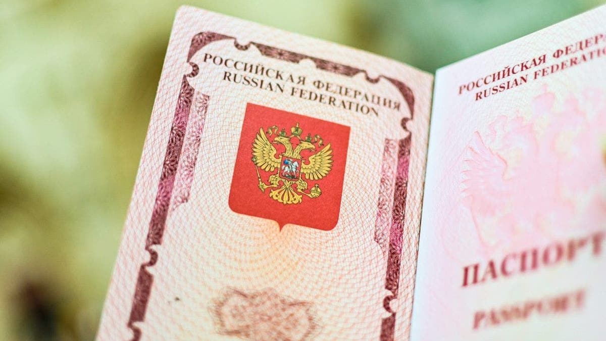 The emblem of the Russian Federation drawn in the passport. A woman shows her Russian passport.