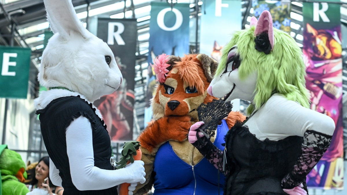 Three furries talking at a conference.