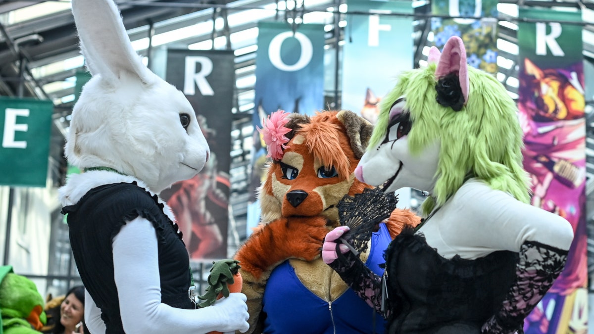 Three furries talking at a conference.