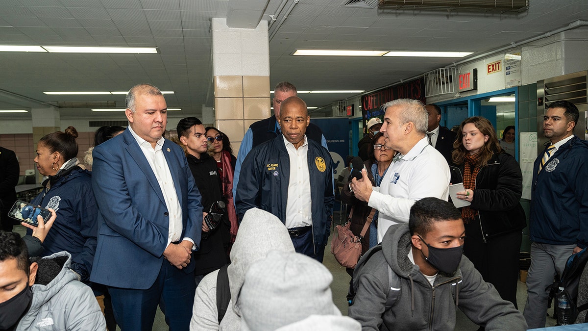 Eric Adams distributes food to migrants at NYC public school 