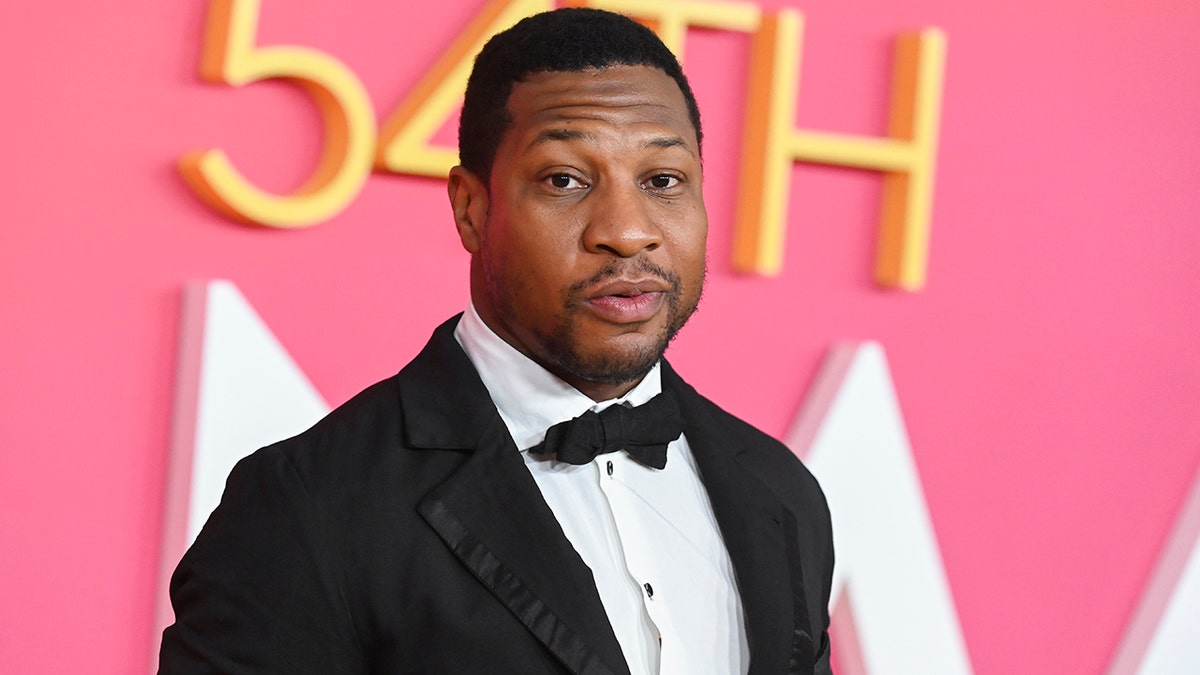 Jonathan Majors looks at the camera on the red carpet in a classic tuxedo at the 54th NAACP Image Awards