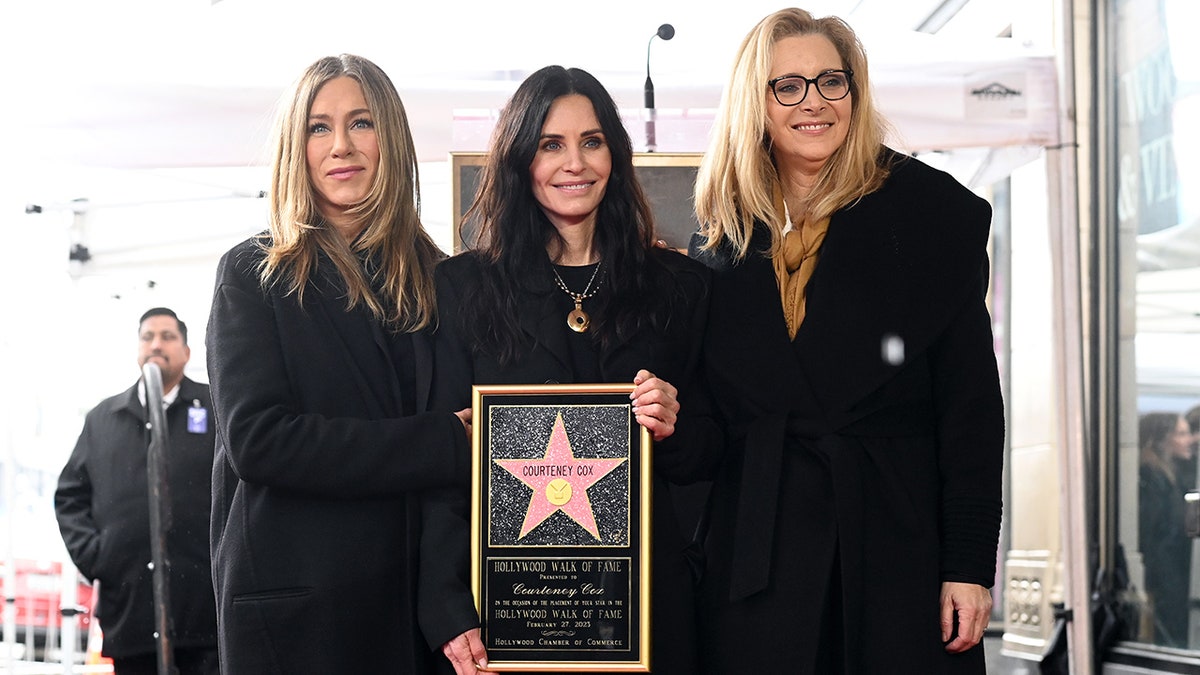Jennifer Aniston and Lisa Kudrow in all-black outfits show up to support Courteney Cox who is receiving her Star on the Walk of Fame, also wearing black, holding her star plaque