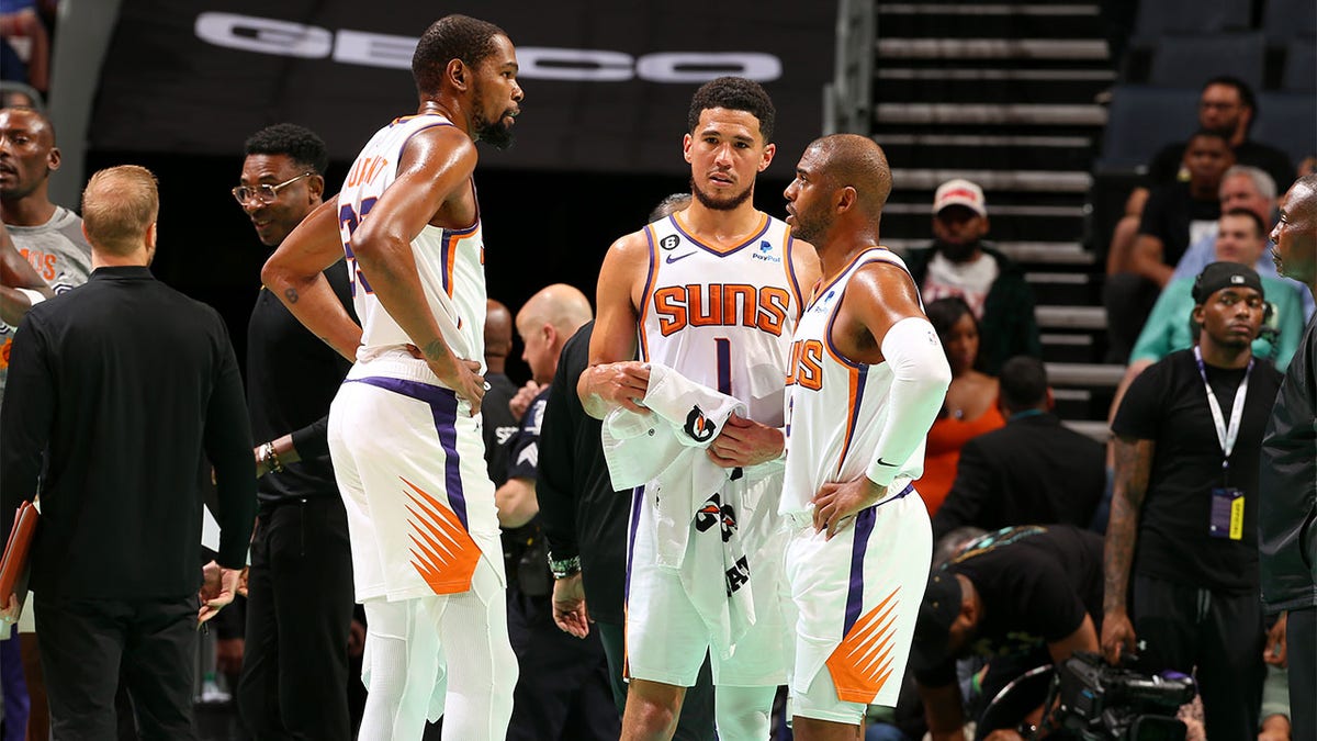 Kevin Durant talks with Devin Booker and Chris Paul
