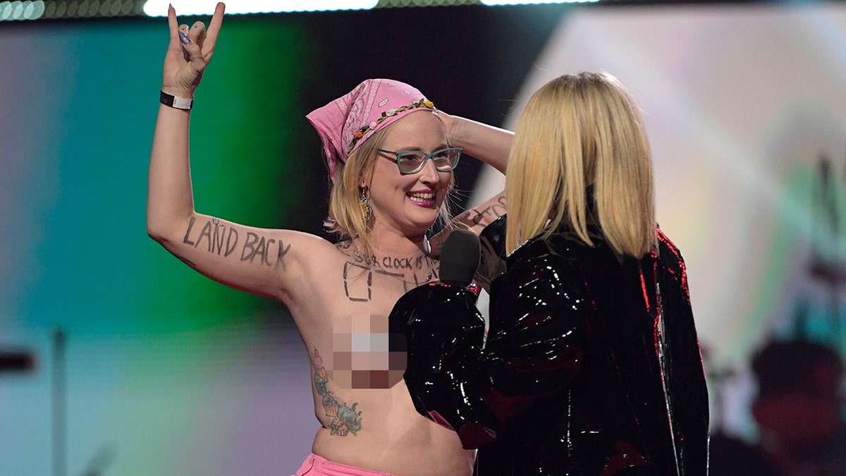 avril lavigne confronts topless protester who smiles at her