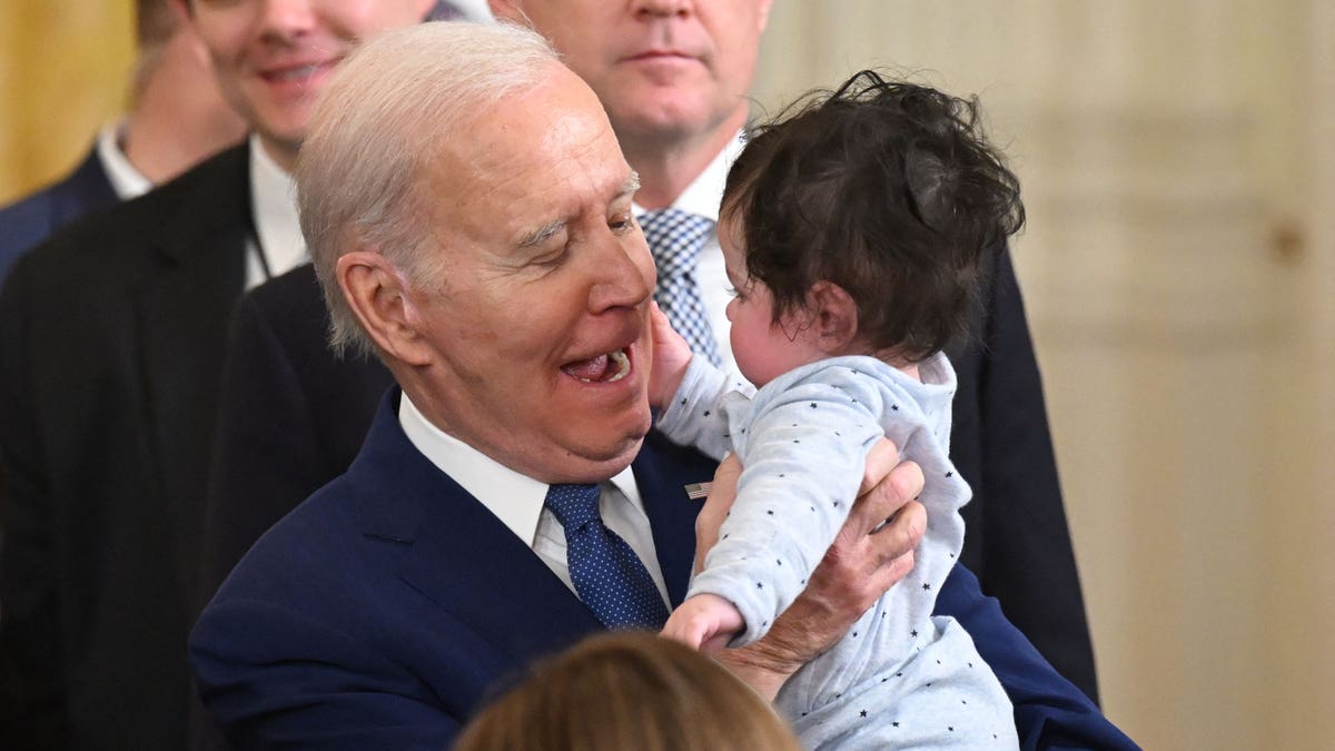 President Joe Biden holds a baby