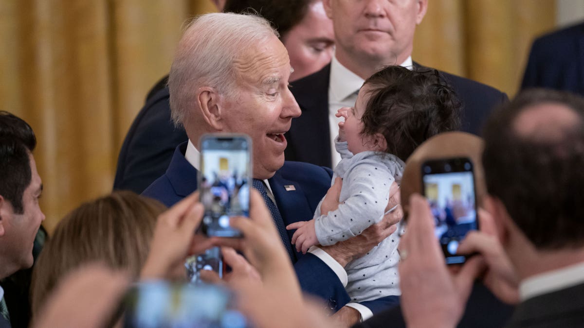 President Joe Biden holds a baby