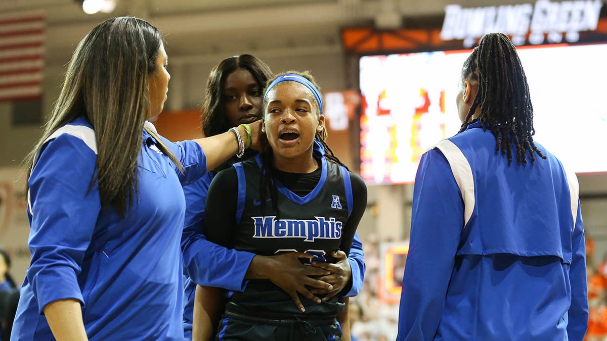 Memphis' Jamirah Shutes is escorted off the court after punching another player