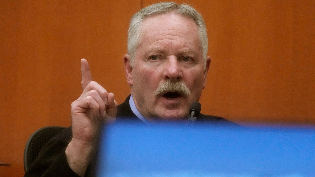 Eric Christiansen points in the air while he takes the stand testifying in the Gwyneth Paltrow ski accident case