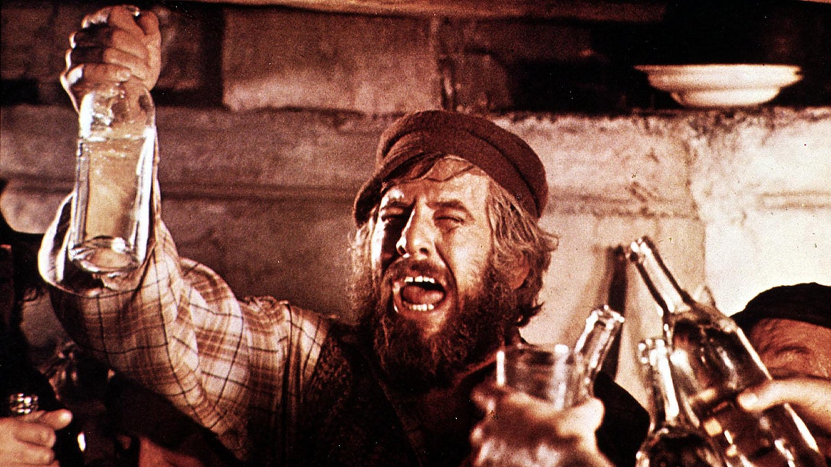 Chaim Topol as Tevye the Dairyman raising a glass in a scene from 'Fiddler on the Roof'
