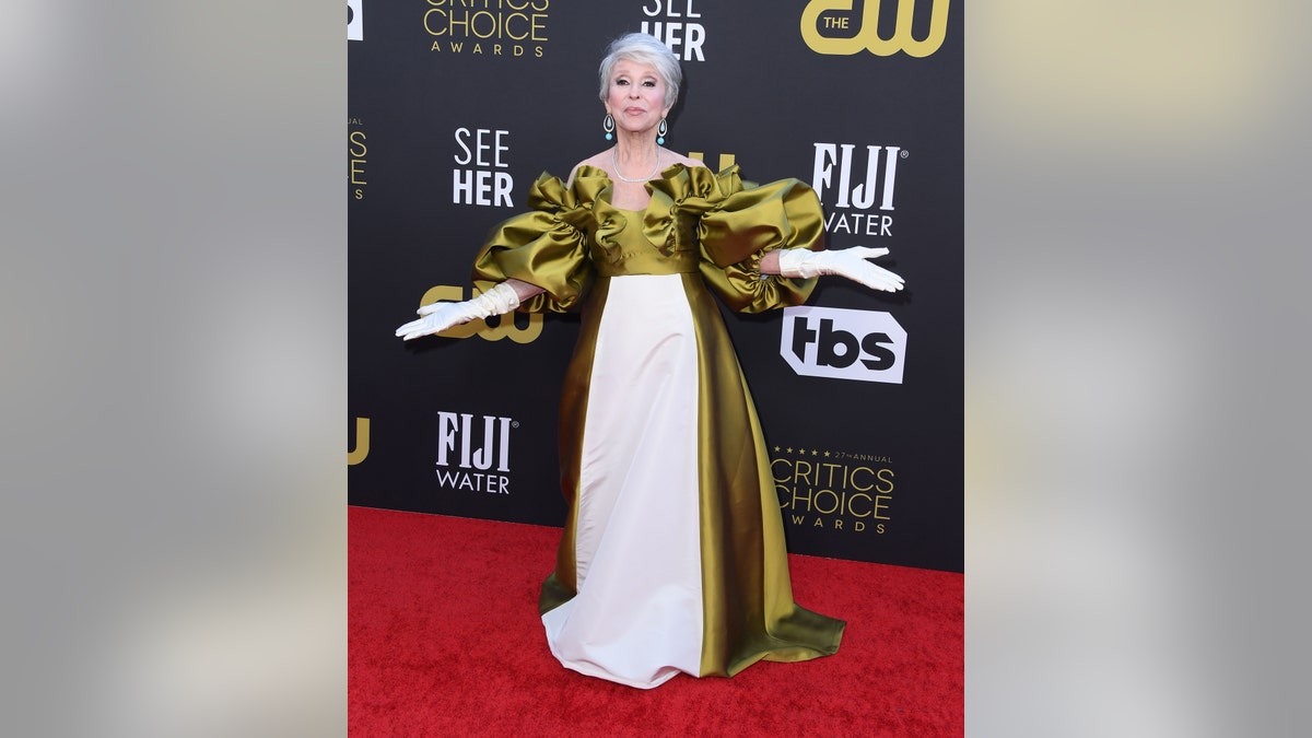 Rita Moreno in an olive green and white gown on the red carpet