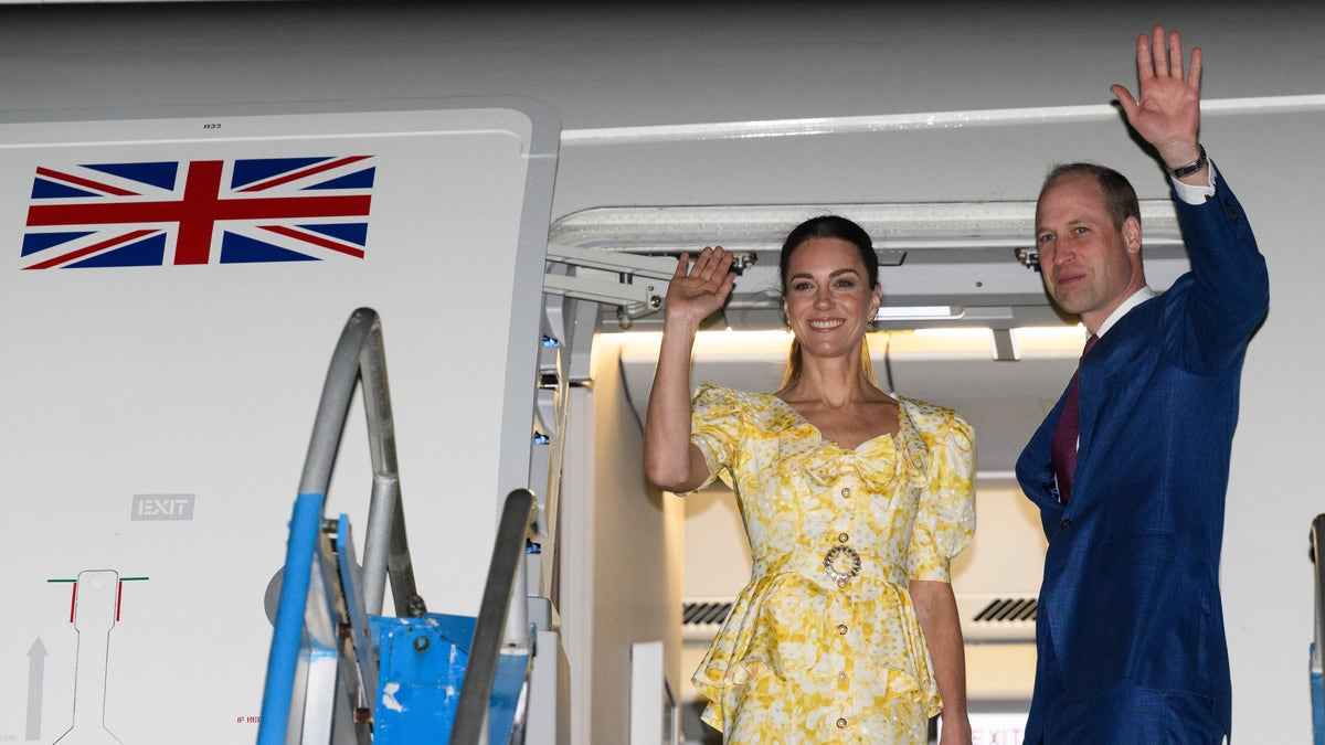 Kate Middleton and Prince William waving from a plane