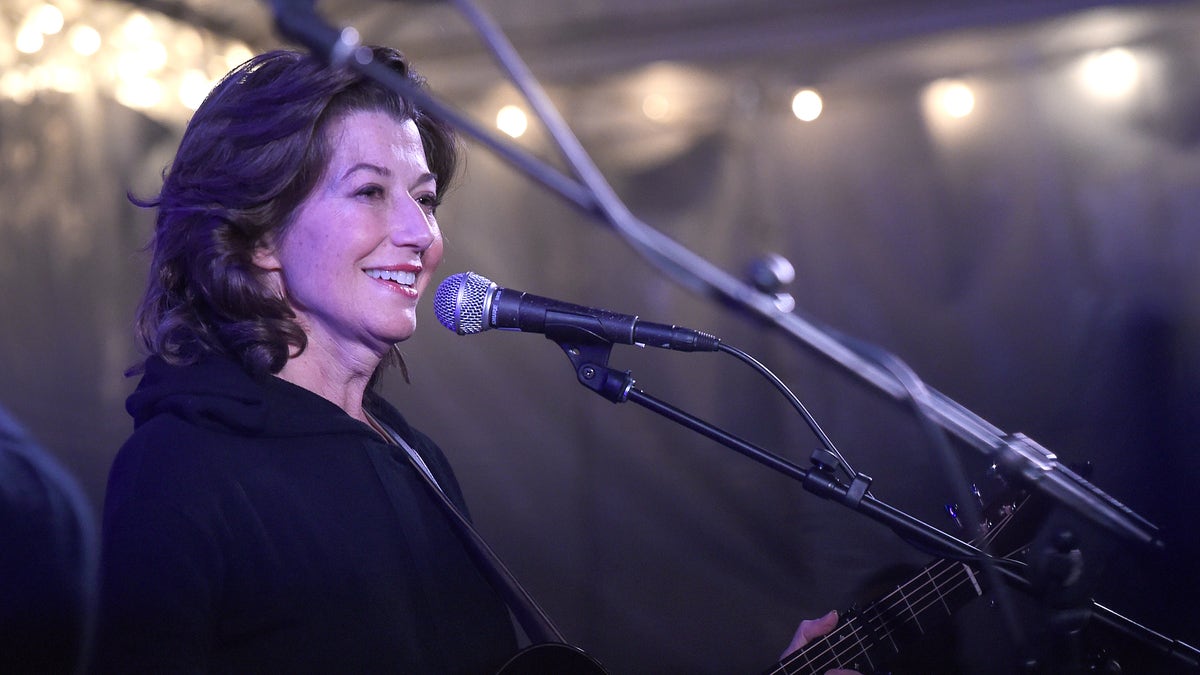 Amy Grant wearing black in front of a microphone on stage