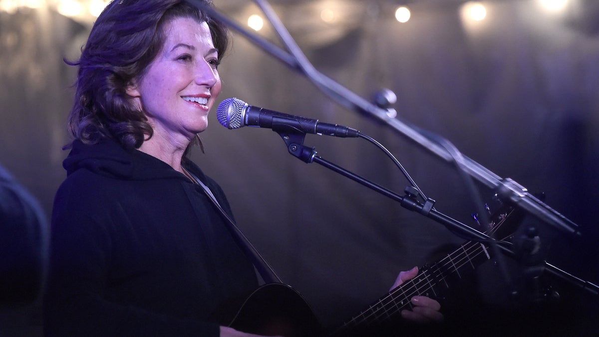 Amy Grant wearing black in front of a microphone on stage