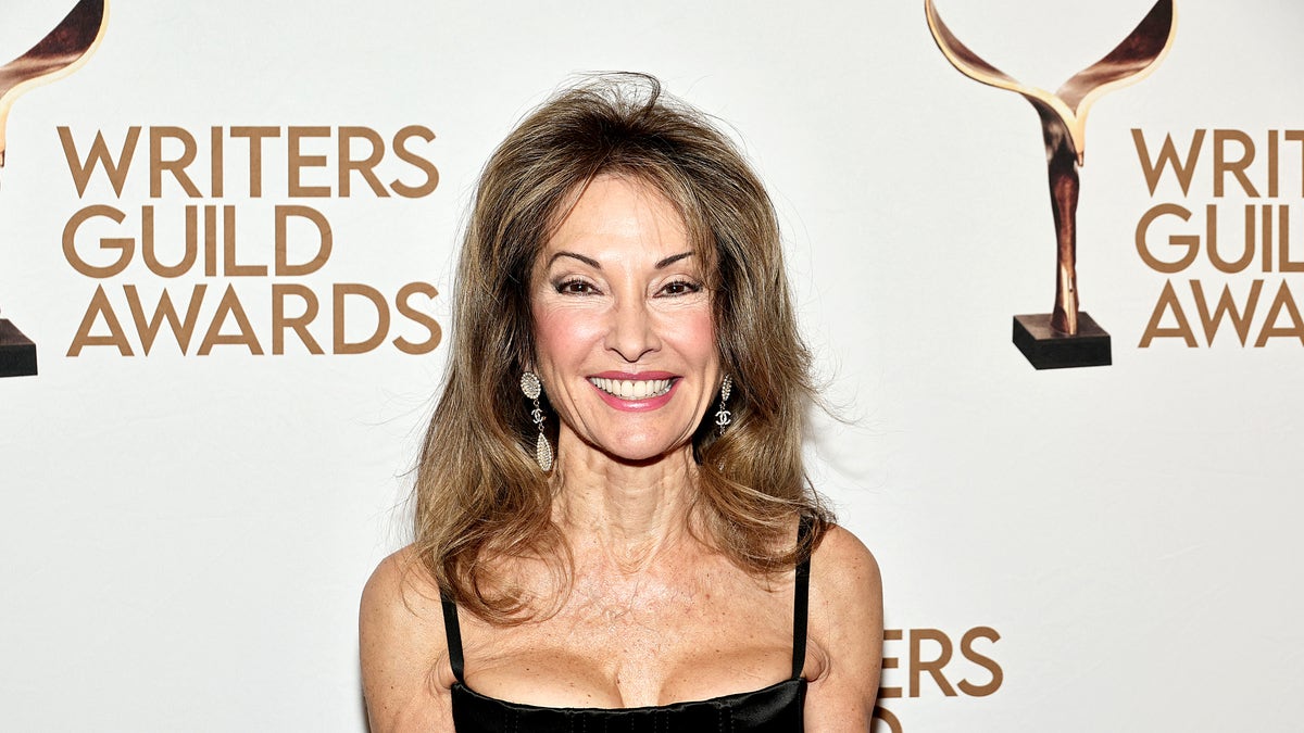 Susan Lucci in a black dress in front of the Writers Guild of America backdrop