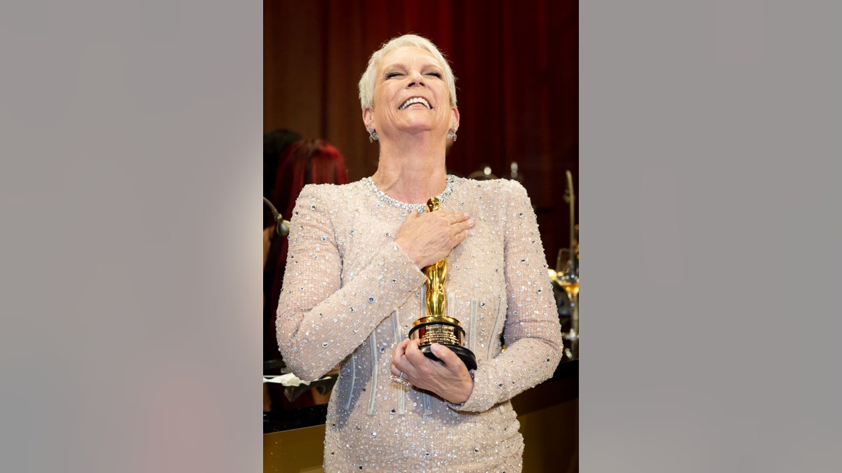 Jamie Lee Curtis holding her Oscar trophy