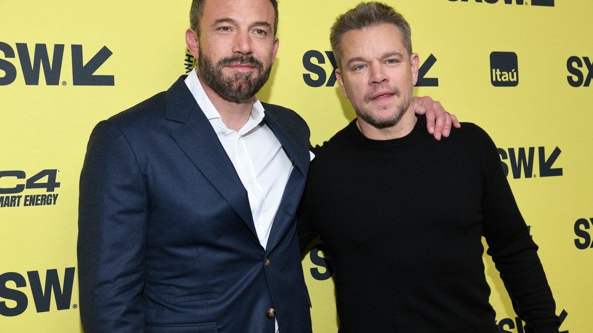 Ben Affleck wearing a suit and Matt Damon wearing a black shirt at south by southwest